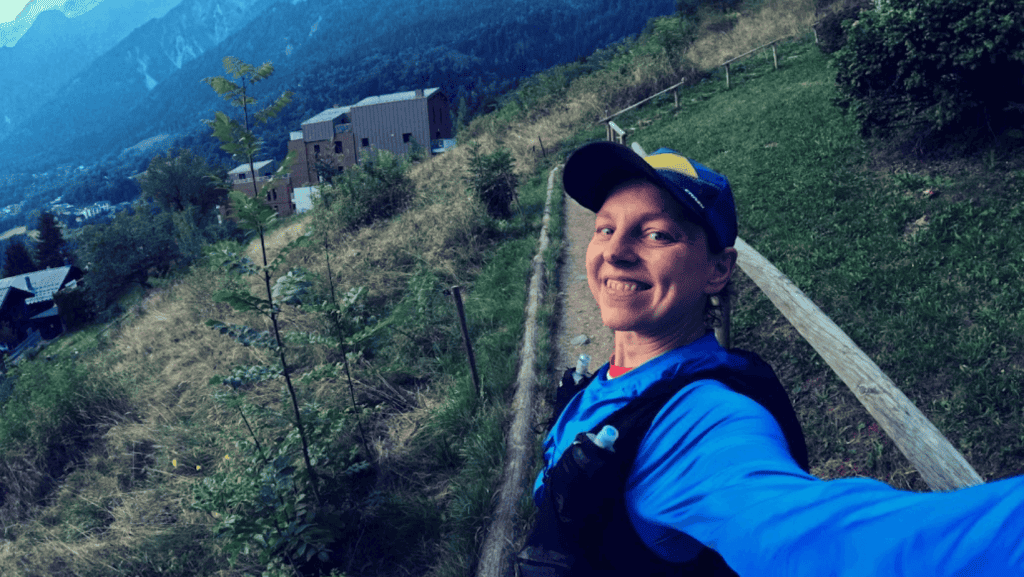woman runner in the Alps smiling in the camera